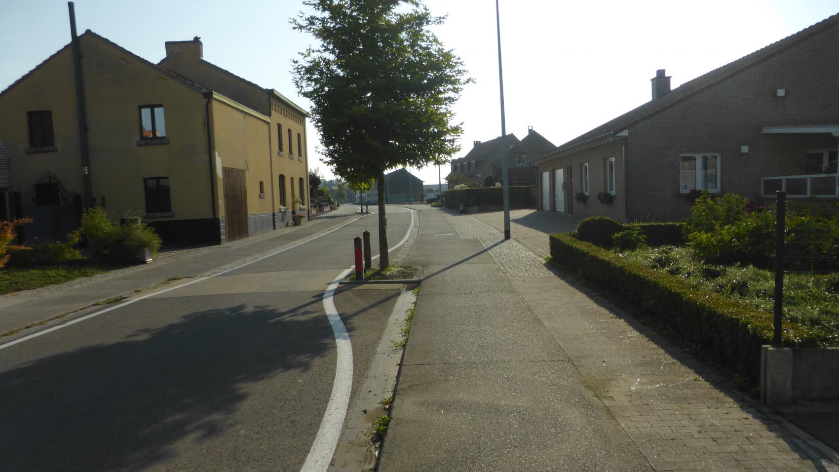 The same location in 2017. Carriageway narrowed, cycle paths continuous and wider, additional section of pavement for pedestrians. There is even space for trees!